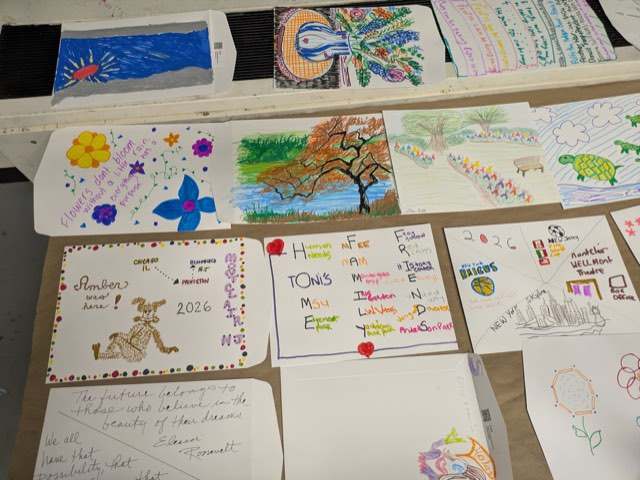 A table covered in hand-drawn and hand-lettered envelopes