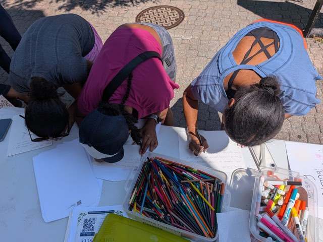 Neighbors decorating envelopes together with colored pencils and markers